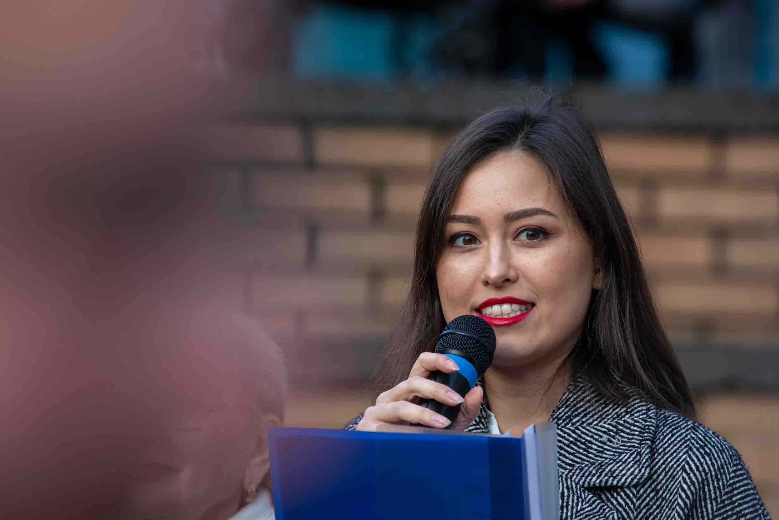 Eine Sängerin einer ukrainischen Gesangsgruppe singt in ein Mikrofon auf dem Weihnachtsmarkttag in Essen Borbeck